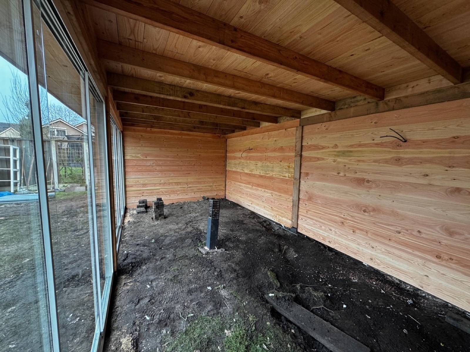 Overkapping in aanbouw met glazen pui